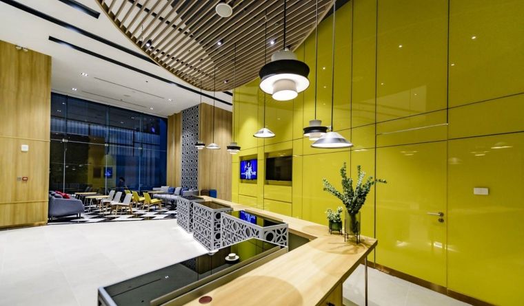 มุม Lobby ของโรงแรม ที่ใช้กระจกเคลือบสี (Colorkote) โทนสีเหลืองสดใสในการกรุปิดผิวผนัง
